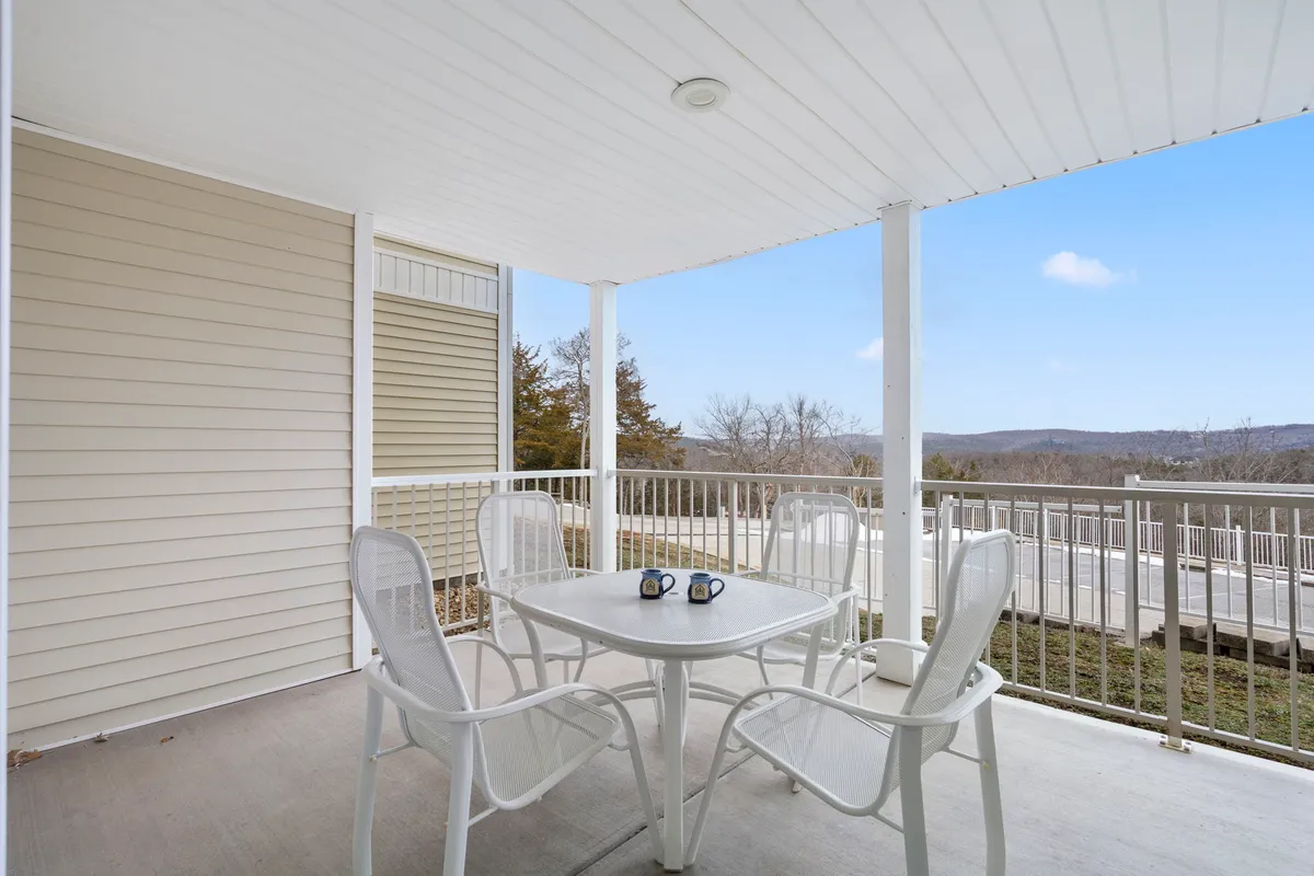A peaceful outdoor patio scene with an inviting table and chairs set against a scenic backdrop. The area is perfect for enjoying morning coffee, evening relaxation, or soaking in the tranquil lake views just beyond.