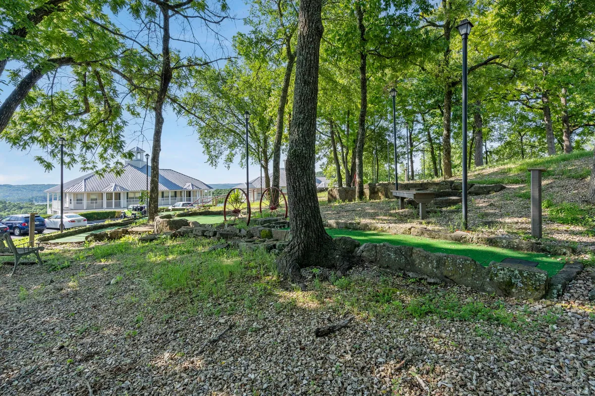This image highlights a mini-golf area surrounded by lush greenery, with a walking path and stone features. The setting suggests a relaxed, social outdoor environment ideal for friendly competitions and casual gatherings.