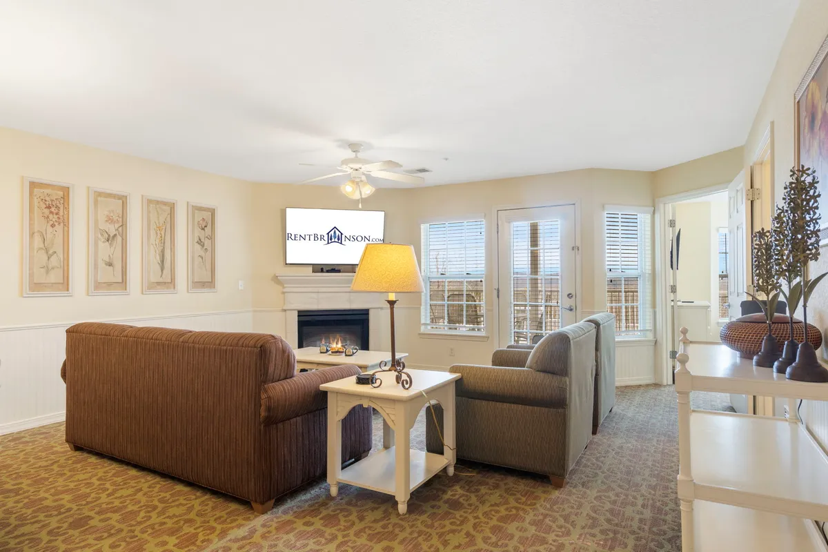 A cozy living room with a plush sofa, a coffee table, a modern fireplace, and a television. The space feels warm, inviting, and impeccably tidy, ideal for relaxing and spending quality time with family or friends.