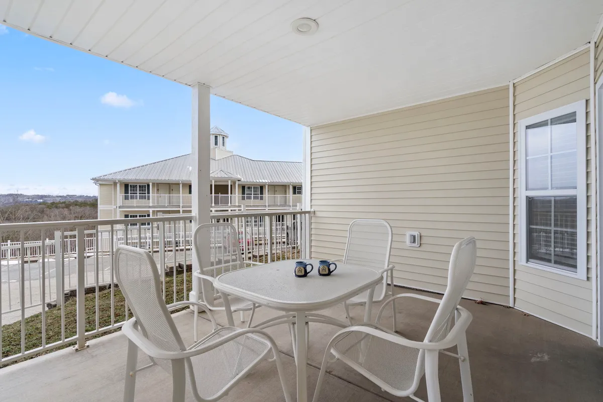 This exterior image features a peaceful patio setting with a table and chairs, coffee mugs resting on the tabletop, and lush surrounding greenery. The space is inviting and serene, perfectly suited for quiet morning rituals or evening relaxation.